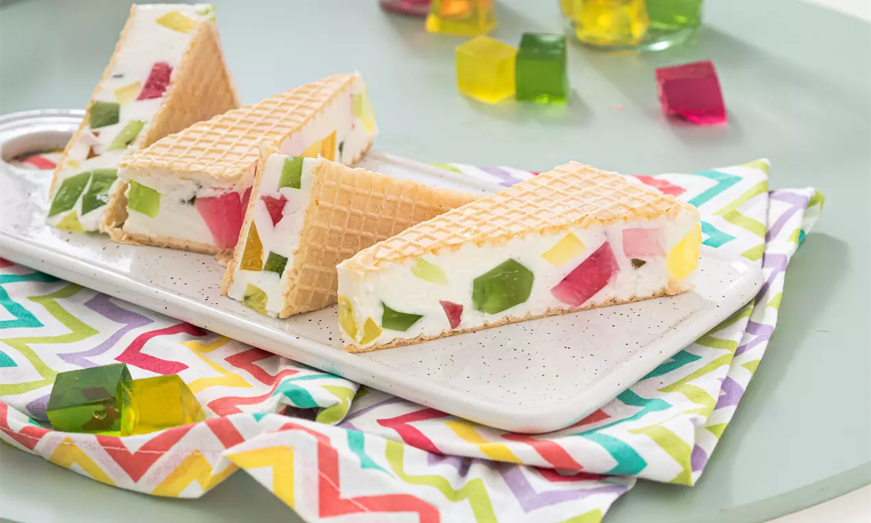 Fotografia przedstawia wafle z pokrojonymi w kostkę kolorowymi galaretkami